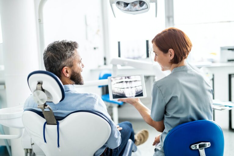 Rear view of man and dentist in dental surgery, annual check-up